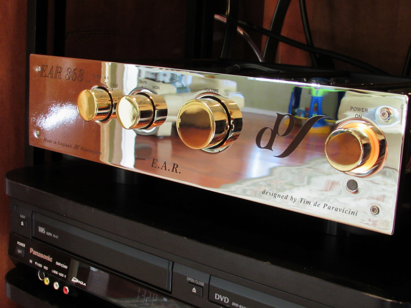 A silver amplifier with gold knobs
