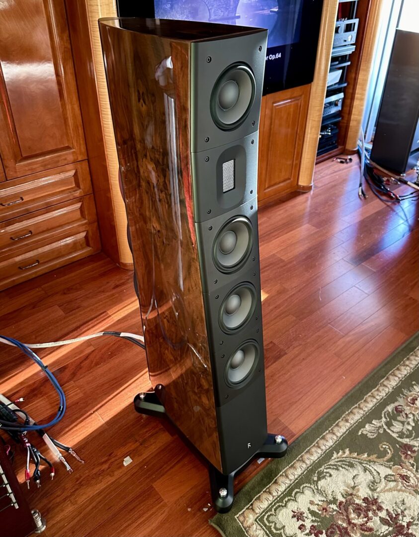 Tall wooden speaker with black drivers.